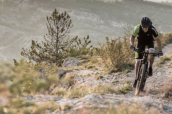 A mountain biker riding a moderately-priced MTB